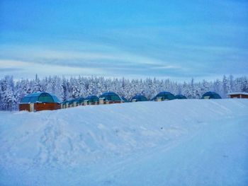 Scenic view of snow covered field against cloudy sky