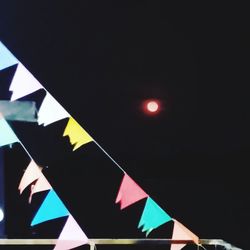 Close-up of flags against clear sky at night