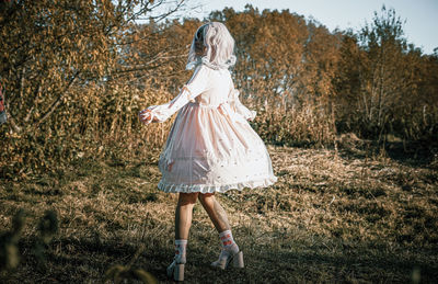 Woman standing by tree on field