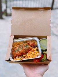 Cropped hand of person holding chaat box