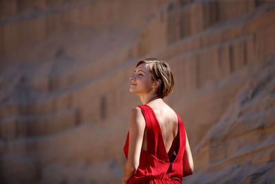 Low angle view of woman looking away against wall