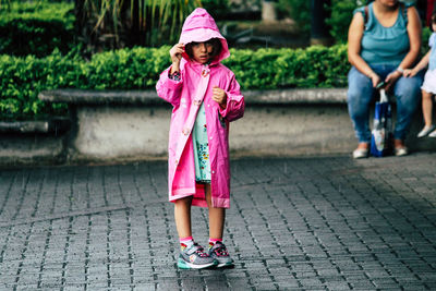 Full length of woman standing with pink umbrella