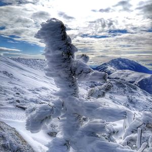 Snow covered landscape against sky