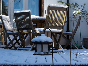 Empty chairs and tables in snow covered field