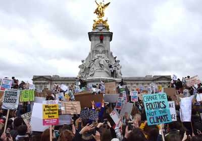 People in front of traditional building against sky during protest