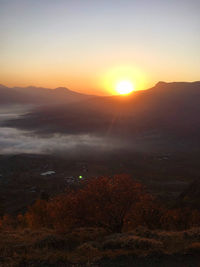 Scenic view of land against sky during sunset