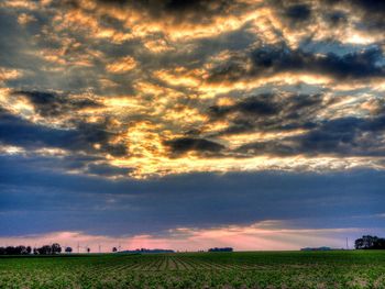 Scenic view of field against cloudy sky