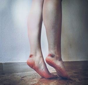 Low section of woman standing on floor at home