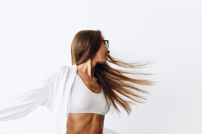 Side view of woman standing against white background