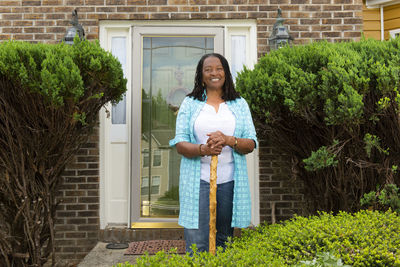 Portrait of an african-american woman standing in front of her house