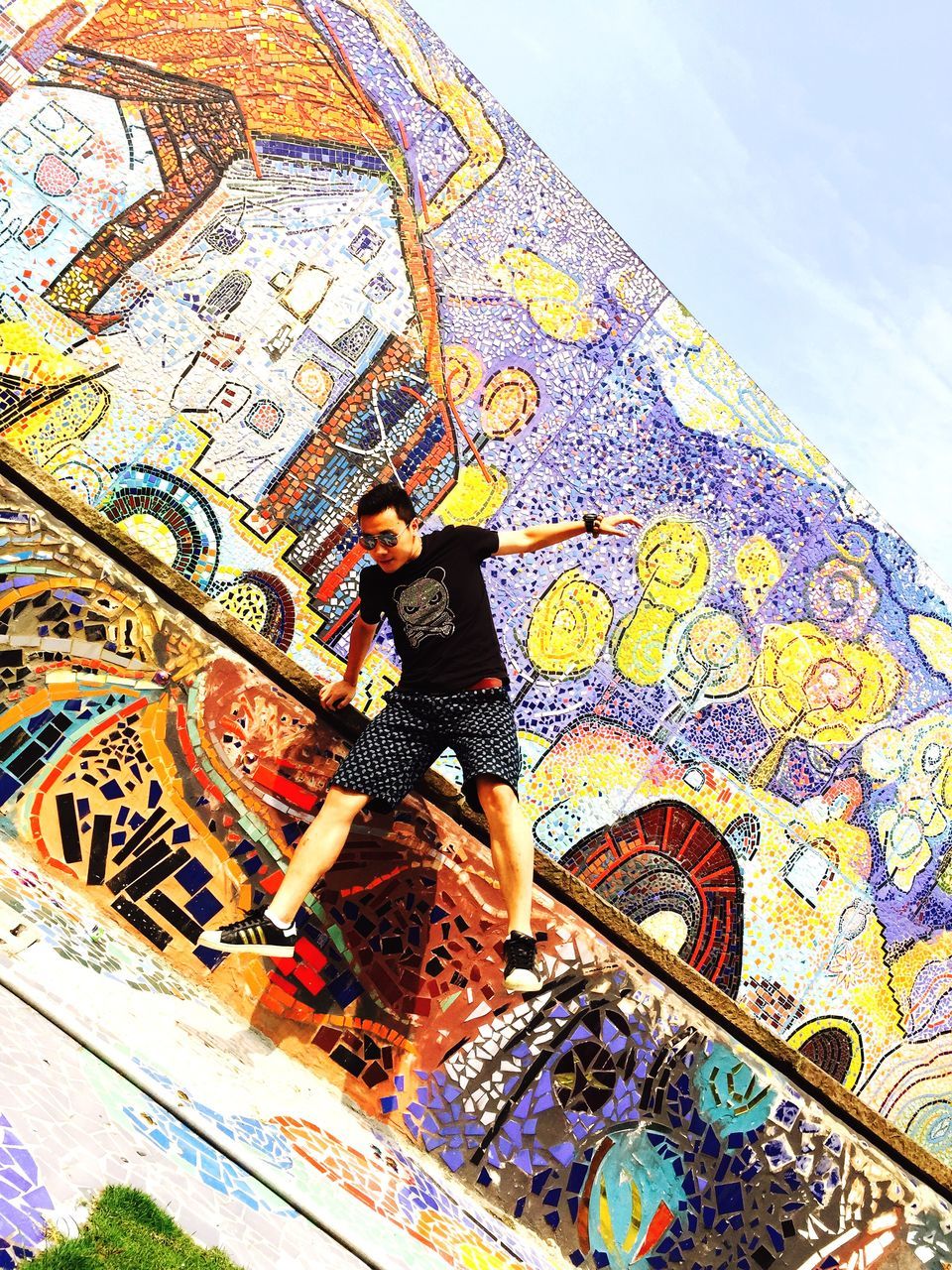 lifestyles, art, creativity, art and craft, leisure activity, multi colored, casual clothing, standing, low angle view, wall - building feature, pattern, graffiti, design, day, full length, sky, person, indoors