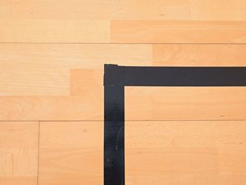 Black corner. worn out wooden floor of sports hall with colorful marking lines