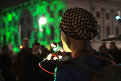 Portrait of man holding illuminated lighting equipment at night