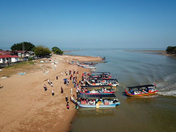 High angle view of people on beach against clear sky