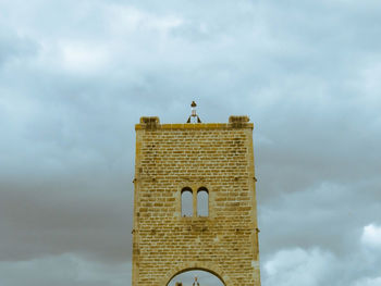 Low angle view of cross on building against sky