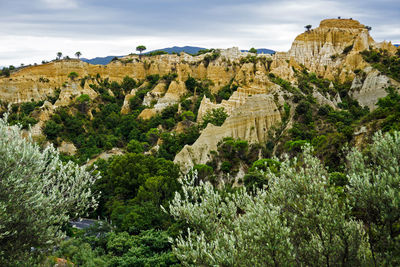 Scenic view of rock formations at les orgues d ille-sur-tet against sky