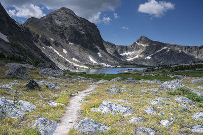 Scenic view of lake by mountains against sky