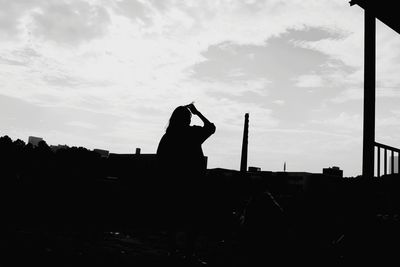 Silhouette man and woman against sky