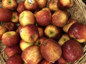 High angle view of apples in wicker basket for sale at market stall