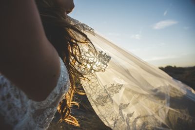 Close-up of bride in veil against sky