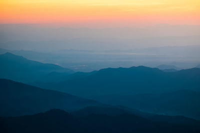 Scenic view of silhouette mountains against sky at sunset