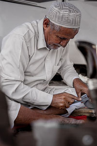 Portrait of senior man sitting on table