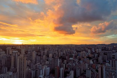 Aerial view of modern buildings against sky during sunset