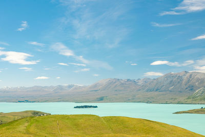 Scenic view of turquoise colored lake tekapo and mountains against sky