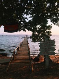 View of wooden walkway leading to sea