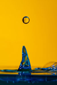 Close-up of water splashing on yellow surface