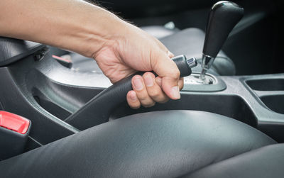 Cropped hand holding gearshift in car