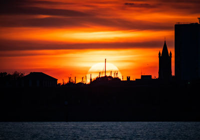 Silhouette of buildings against sky during sunset taken from portsmouth looking towards gosport