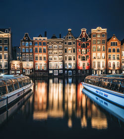 Canal by buildings against sky in city