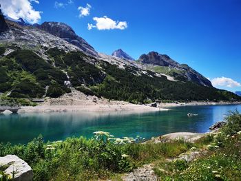 Scenic view of lake and mountains against blue sky