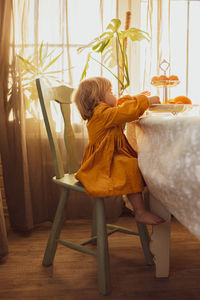 Girl sitting on chair at home