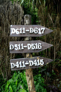Close-up of directional sign against plants
