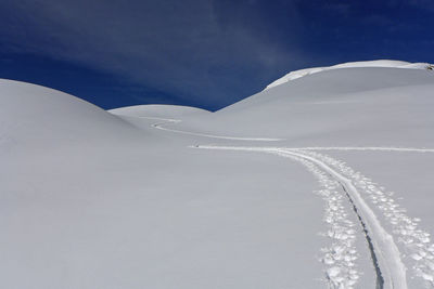 Scenic view of snow covered land against sky during winter