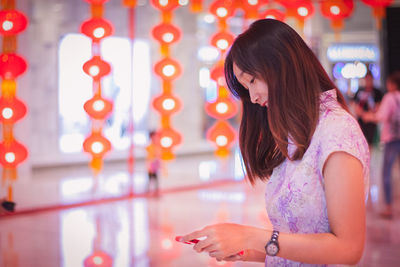 Woman standing against illuminated lights