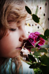 Close-up of girl smelling pink flower