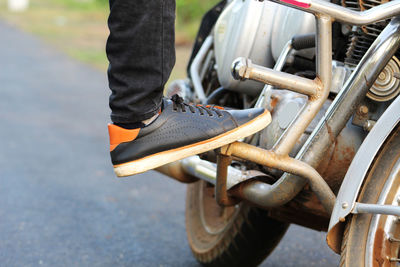 Low section of man standing on motorcycle