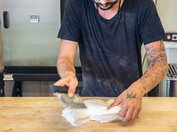 Midsection of man preparing food at table