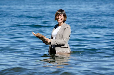 Portrait of smiling young man standing in sea