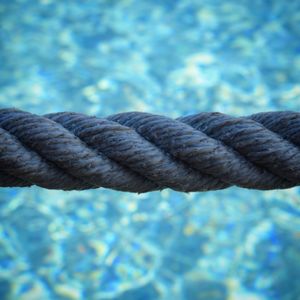 Close-up of rope against blue water