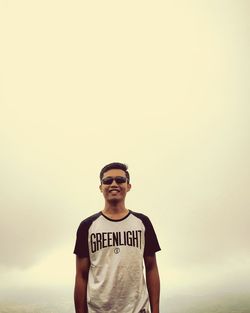 Portrait of young man standing against sky