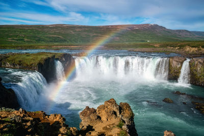 Scenic view of waterfall against sky