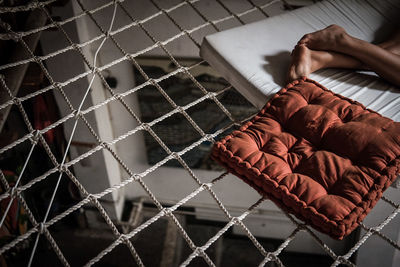 Low section of woman resting on hammock over room at home