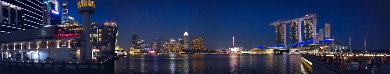 Panoramic view of harbor and illuminated buildings at night