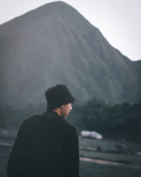 Rear view of man looking at snowcapped mountain