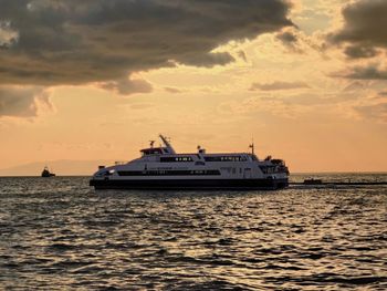 Ship sailing on sea against sky during sunset