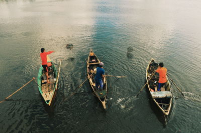 Rear view of men boating on lake